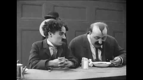 CIRCA 1914 - In this silent comedy, a man (Charlie Chaplin) gets into a fight with a man who slurps his soup annoyingly at a cafeteria.