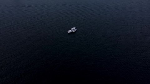A beautiful aerial drone reveal shot, flying over a white boat towards the coastline in Long Beach, California