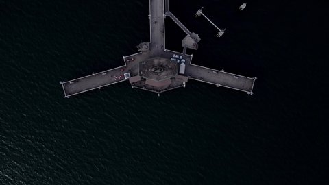 Aerial bird's eye view drone shot, drone flying along with Belmont Veterans Memorial Pier in Long Beach, California.