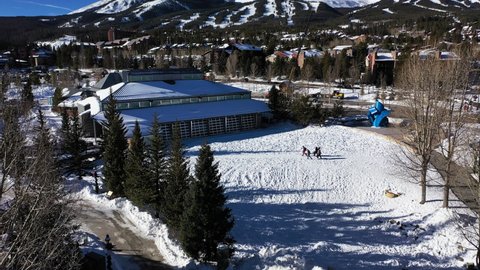Aerial view of four friends getting ready to enjoy the snow in colorado, united states with the mountains in the background - drone shot
