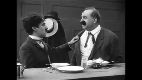 CIRCA 1914 - A man (Charlie Chaplin) starts a fight with an obnoxious man in a restaurant and ends up throwing a pie in the face of a pedestrian.