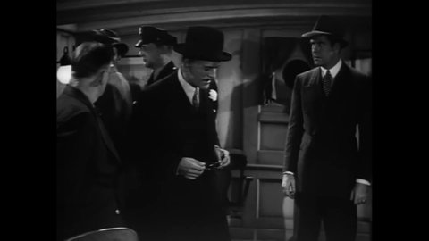 CIRCA 1939 - In this mystery movie, a detective (Boris Karloff in yellow face) accuses a man of murder.
