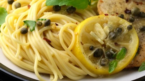 Chicken Piccata with capers, white wine sauce and spaghetti. Rotating video