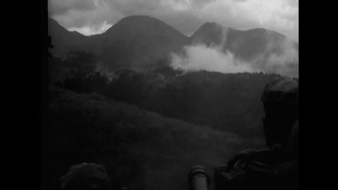 CIRCA 1945 - American soldiers fire 105mm Howitzers in the hills of Luzon, the Philippines.