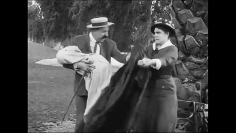 CIRCA 1914 - A man (Charlie Chaplin) is happily reunited with his wife and baby after fixing a misunderstanding with another couple.