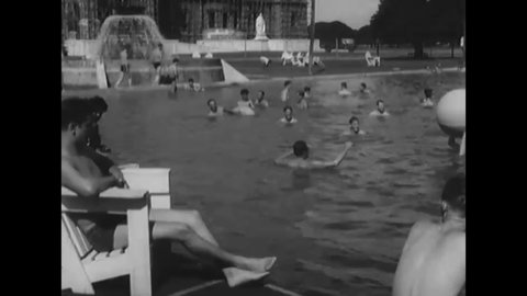 CIRCA 1945 - A lifeguard watches over soldiers swimming and playing in the pool outside Calcutta's Victoria Memorial.