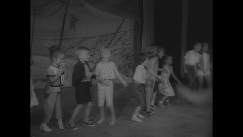 CIRCA 1966 - Kids dance the twist with a circus elephant under the big top.