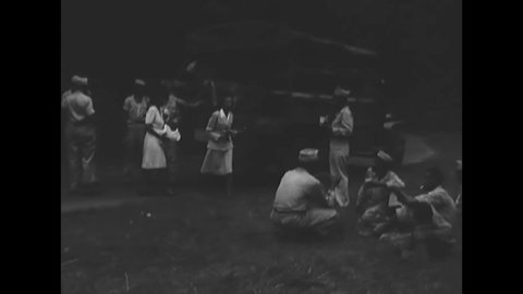 CIRCA 1945 - African-American Red Cross workers give drinks and food to soldiers in a field outside Calcutta.