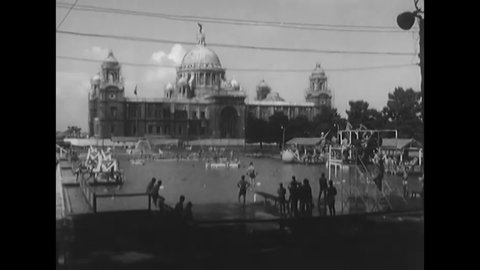 CIRCA 1945 - American soldiers swim and dive in a pool outside the Victoria Memorial in Calcutta, India.