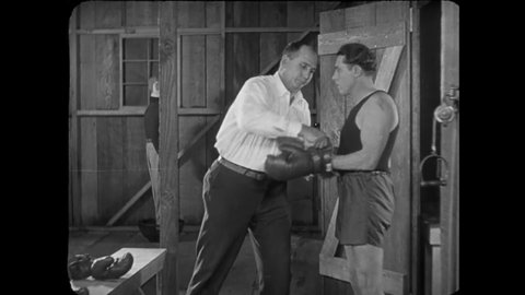 CIRCA 1926 - In this silent comedy, a man (Buster Keaton) gets stuck in the ropes of a boxing ring.