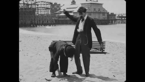 CIRCA 1915 - In this silent comedy, a man (Charlie Chaplin) befriends another on the beach.