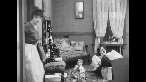 CIRCA 1914 - In this silent comedy, a man (Charlie Chaplin) and his wife argue at home, concluding with her throwing a horseshoe at his head.