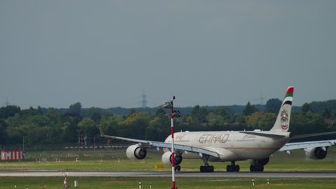 DUSSELDORF, GERMANY - JULY 22, 2017: Etihad Airbus A340 taking off at Dusseldorf Airport (DUS). Rear view, passenger plane flies away