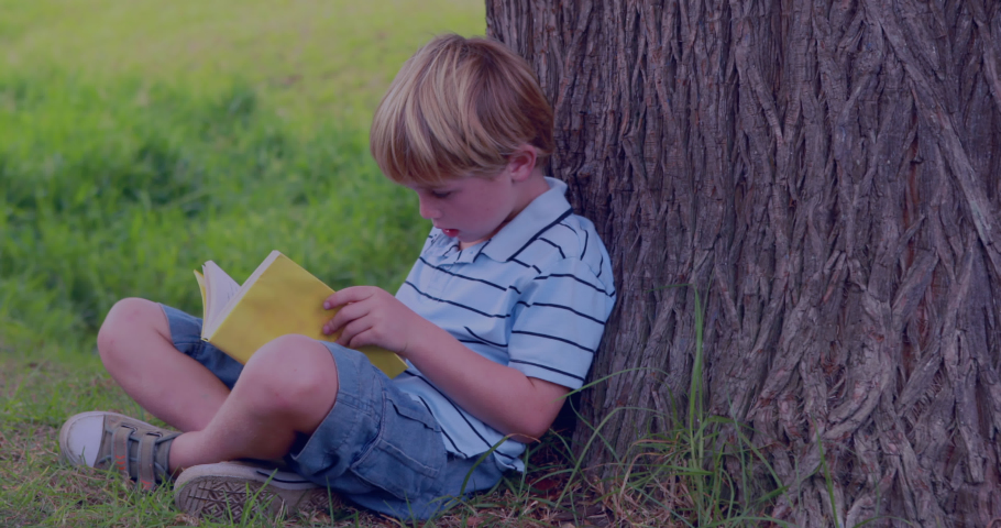 Animation of light trails over caucasian boy reading book. children