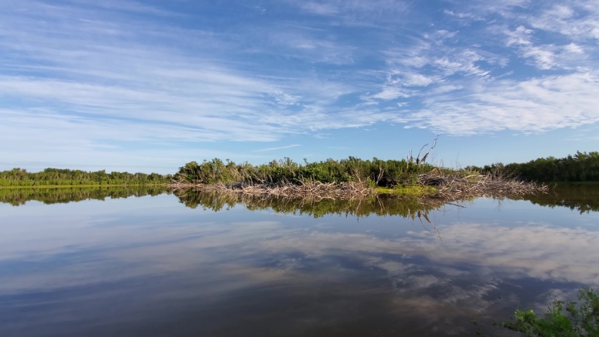 Timelapse of morning clouds over Eco Pond in Everglades National Park, Florida reflected in pond