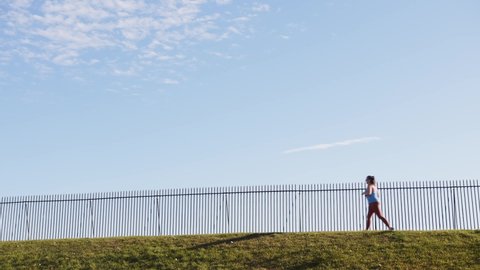 Rochester, NY, 01 October 2020 – People walk and run on a footpath in front of a bright blue sky