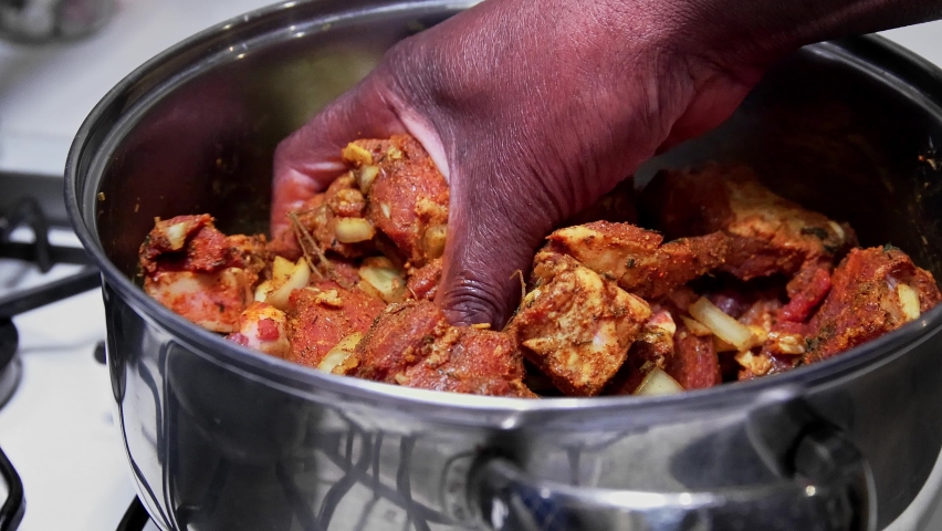 Jamaican curry goat marinated and mixed by hand.  Slow motion | Shutterstock HD Video #1087462190