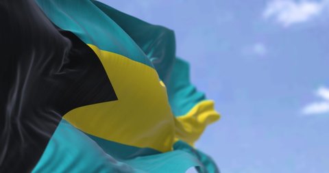 Detail of the national flag of the Bahamas waving in the wind on a clear day. Bahamas is a sovereign country within the Lucayan Archipelago of the West Indies in the Atlantic. Selective focus. 