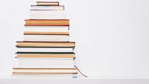 Stop motion animation of growing and shrinking stack of books isolated on white background. Educational or learning concept.