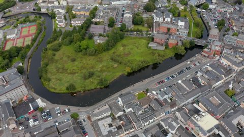 High angle footage of river winding through town. Aerial panoramic shot of city from height. Ennis, Ireland