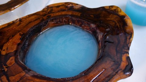 The process of making a craft table made of resin and wood. Liquid Epoxy Blue Cured Resin