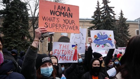 Kharkiv, Ukraine - March, 08, 2021: Many girls with placards: I am a woman, Why are you a superwoman on the women's solidarity march fighting for gender equality during the spring festival