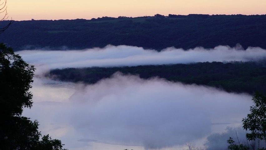 Long time lapse of the sun rising and foging over a lake in Minnesota