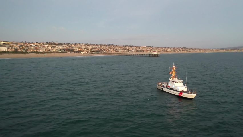 Coastguard Boat Floating At Littoral Zone Of California Coast At Sunset. - aerial