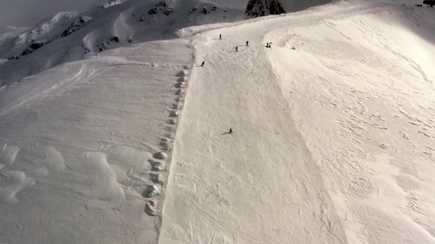 AERIAL - People slalom skiing in mountains at Kolasin ski resort, Montenegro, reverse