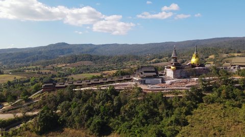 Aerial footage towards Wat Somdet in Phu Ruea as a cares towards the left and then the lovely landscape of Ming Mueang, Loei in Thailand.