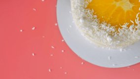 Cake with orange and coconut shavings spun on a pink background. - Powered by Shutterstock - Get 15% off with code: PIKWIZARD15