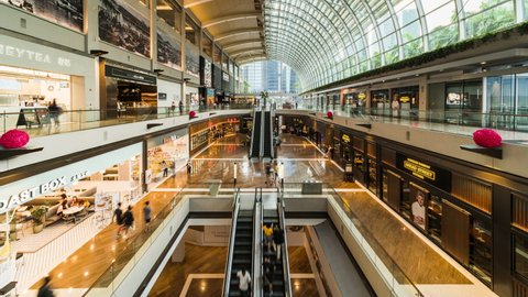 Singapore, Singapore - Feb 4, 2020: Time-lapse of people or tourist traveler walk in the Shoppes at Marina Bay Sands mall. Asian city life, Asia travel lifestyle, or financial economy business concept