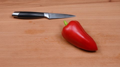 Removing Red Pepper Seeds on a wooden plank. Сleaning red bell pepper. 4K UHD video footage 3840X2160.