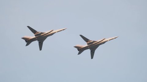Minsk, Belarus - June 28 2018: Two Russian Tu 22M3 supersonic bombers fly side by side in the blue sky. Russian military aviation, air force, carrier of nuclear weapons.