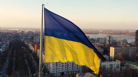 Flag of Ukraine against the backdrop of sunrise. Yellow-blue flag of Ukraine wind waving. Ukraine National symbol.
