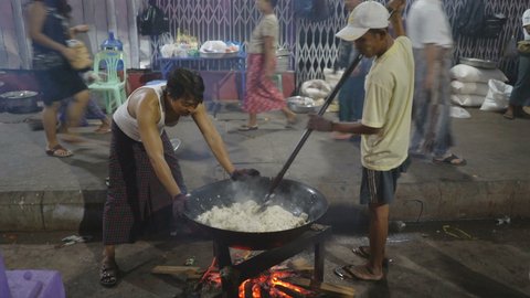 YANGON, MYANMAR - 18TH FEBRUARY, 2019: Local men cook food in the street of the Yangon, Myanmar, Asia