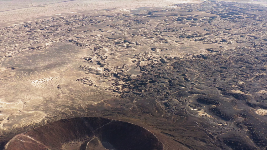 Cinematic Aerial view of Amboy Crater dormant cinder cone volcano Mojave Desert of southern California, drone fly above scenic natural unpolluted landscape in a remote unexplored area of USA
