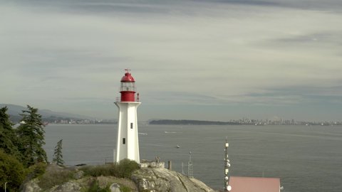 Aerial orbiting shot of historical landmark Point Atkinson Lighthouse by day, West Vancouver, British Columbia, Canada. in 4K