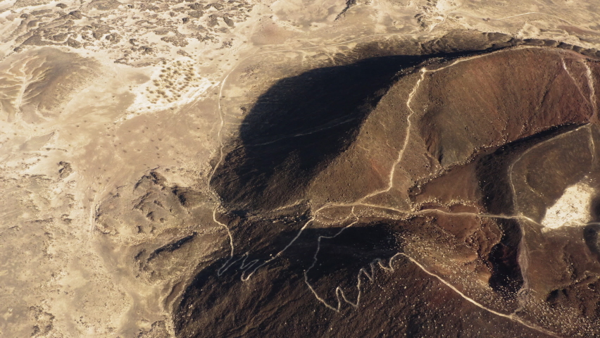 Drone fly close to Amboy Crater dormant volcano in Mojave Desert of southern California, aerial natural landscape wilderness remote travel destination