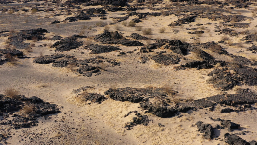 Drone fly above Mojave Desert of southern California revealing Amboy Crater dormant volcano in lava field formation, aerial landscape of famous travel destination for Route 66 road trip