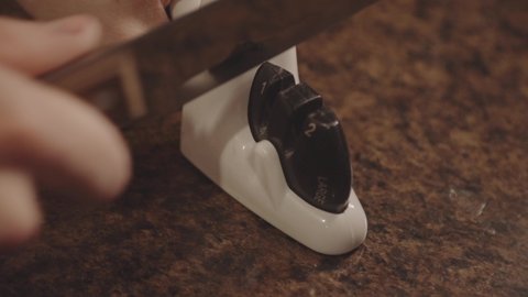 Sharpening Stainless Kitchen Knife With A 2-Stage Electric Knife Sharpener. close up