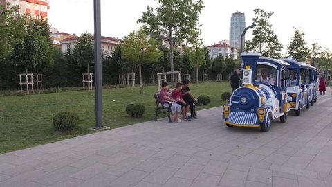 Maltepe, Istanbul, Turkey - 07.26.2021: toy train carrying some people inside of public park in the evening time in summer time for entertainment amusement having fun leisure time concepts 
