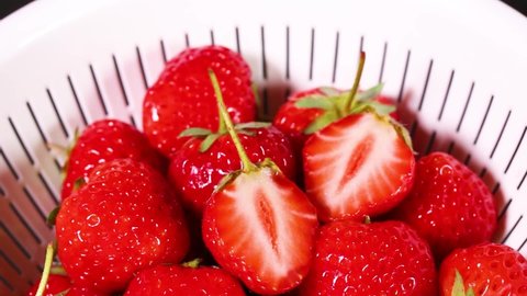 Fresh strawberries in a colander rotating