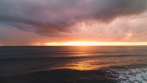 Ocean beach sunrise. Aerial view of sea waves and dramatic clouds, 4k slow motion video