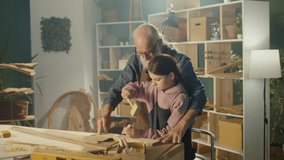 Grandfather Carpenter with Granddaughter Work with Wood to Create Items or Furniture Using Carpentry Tools. Training in Craft Skills in Home Workshop. Communication of Generations. Handicraft, Hobby. - Powered by Shutterstock - Get 15% off with code: PIKWIZARD15