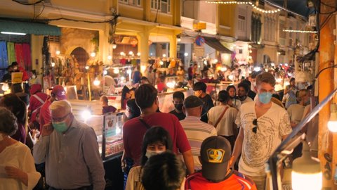 Tourists Walking at Famous Phuket Old Town Sunday Night Market. High Quality 4K Footage. 20 FEB 2022 - Phuket, Thailand.