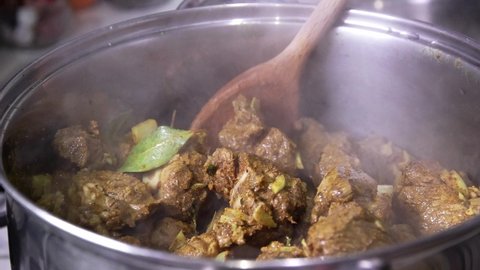 Cooking Jamaican curry goat.  Stirring the pot.  Real time