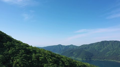 Cinematic revealing drone shot of a lake in Hakone , Japan