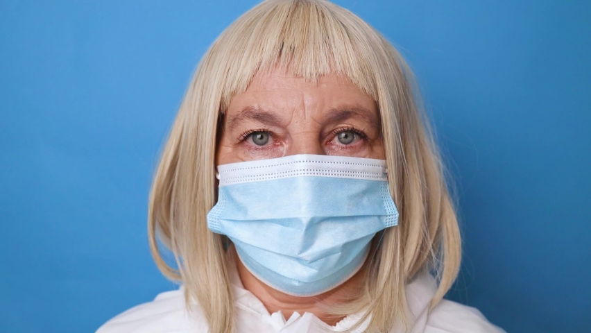 Portrait of female doctor or nurse wear blue gloves wearing medical mask in hospital.