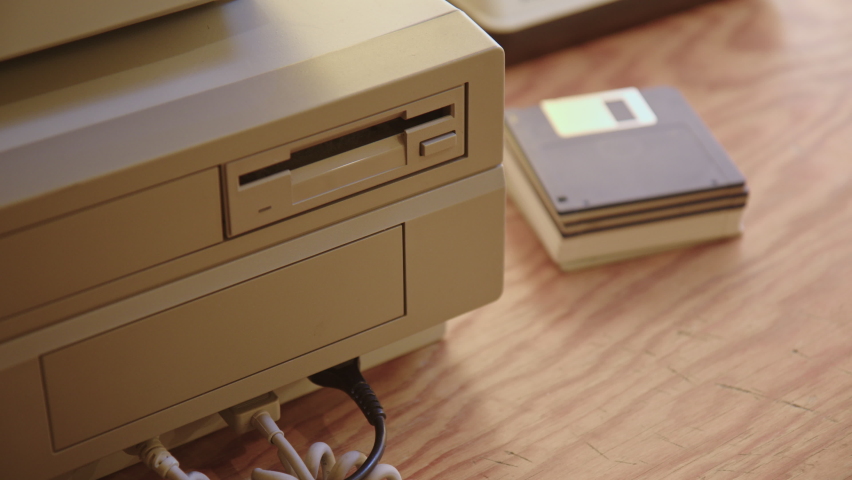 Hand inserting and ejecting Floppy Disk into vintage Commodore Amiga 2000 PC. Drive starts working, LED lights up. Popular Gaming PC in the 80s and 90s. With sound. | Shutterstock HD Video #1087537307